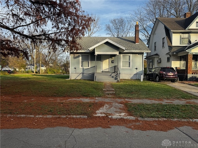 bungalow-style home with a front yard