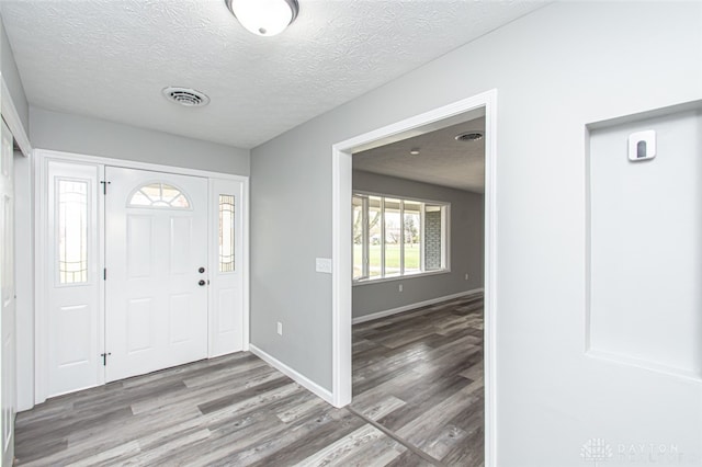 entryway with a textured ceiling and light wood-type flooring