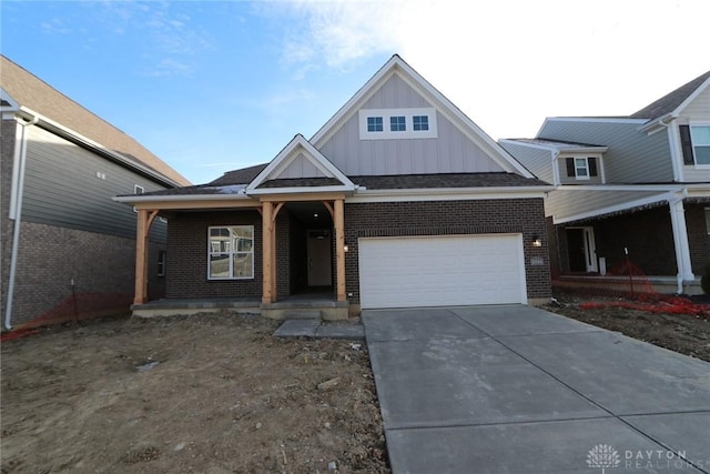 view of front of property featuring a garage, concrete driveway, brick siding, and board and batten siding