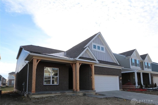 view of front of home with a porch, a garage, brick siding, concrete driveway, and board and batten siding