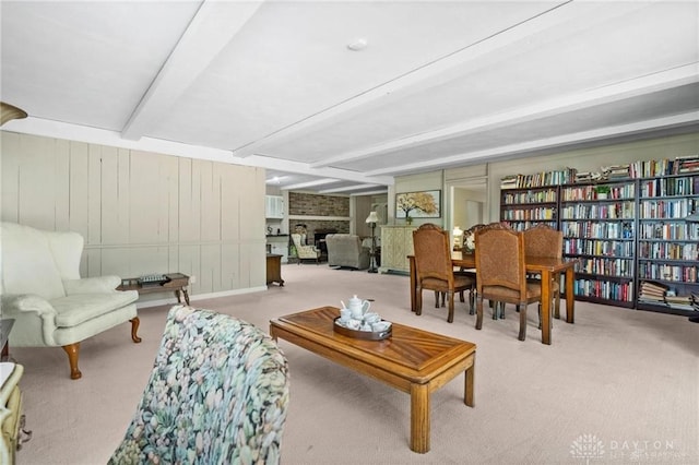 living room featuring light carpet, a fireplace, and beamed ceiling