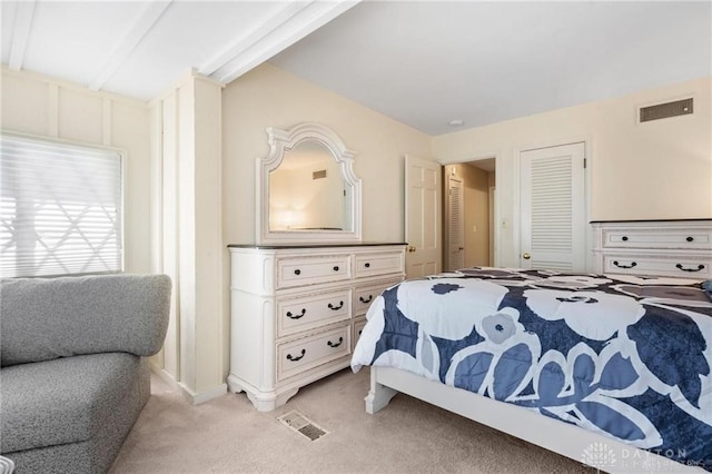 carpeted bedroom with beam ceiling