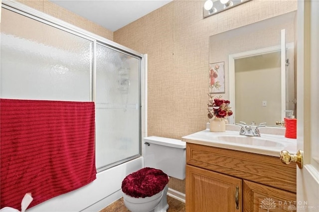 full bathroom featuring vanity, toilet, and bath / shower combo with glass door