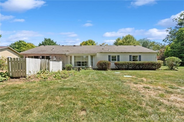 rear view of property featuring a yard