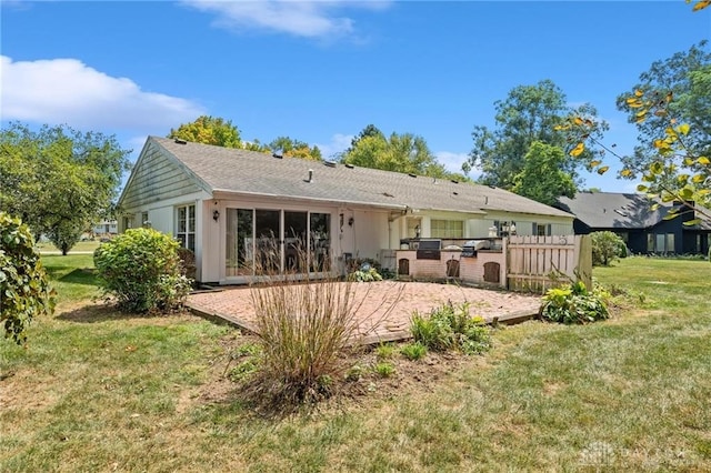 back of house with a lawn and a patio