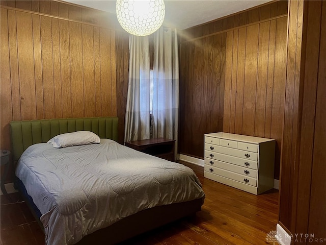 bedroom featuring wooden walls and dark hardwood / wood-style flooring