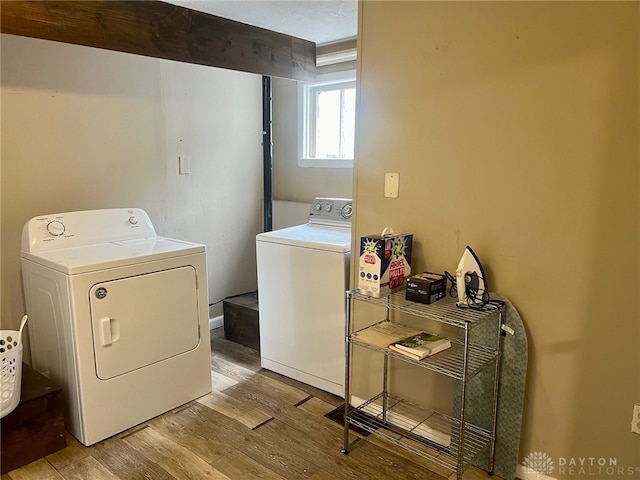 clothes washing area featuring washer and clothes dryer and light hardwood / wood-style flooring