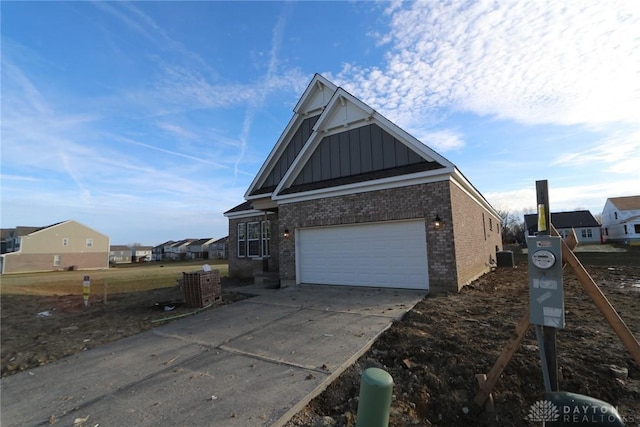 view of front of house featuring board and batten siding, a residential view, concrete driveway, and a garage