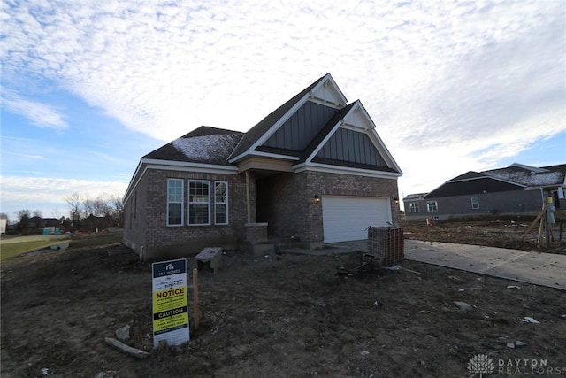 view of front of property featuring board and batten siding, brick siding, and a garage