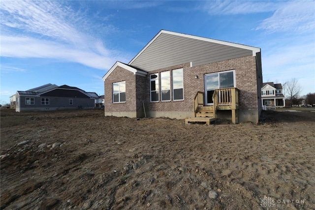 rear view of house featuring brick siding