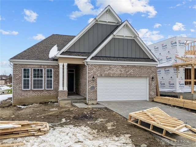 view of front of home with a garage, concrete driveway, and brick siding