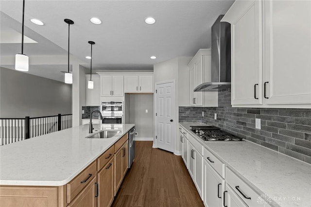 kitchen with an island with sink, light stone counters, and white cabinets