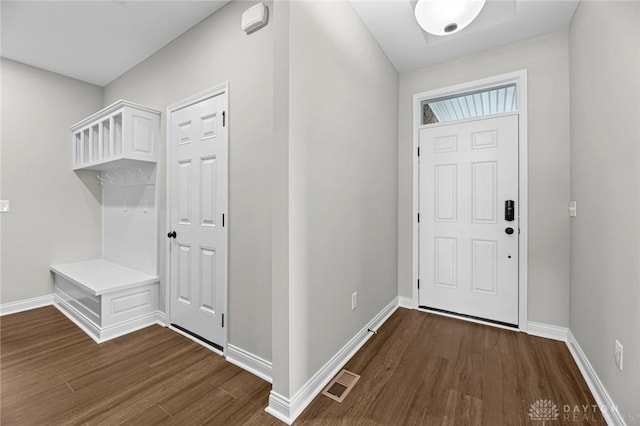 foyer featuring dark wood-type flooring, visible vents, and baseboards