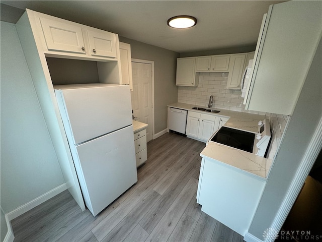 kitchen with white cabinetry, sink, tasteful backsplash, white appliances, and light wood-type flooring