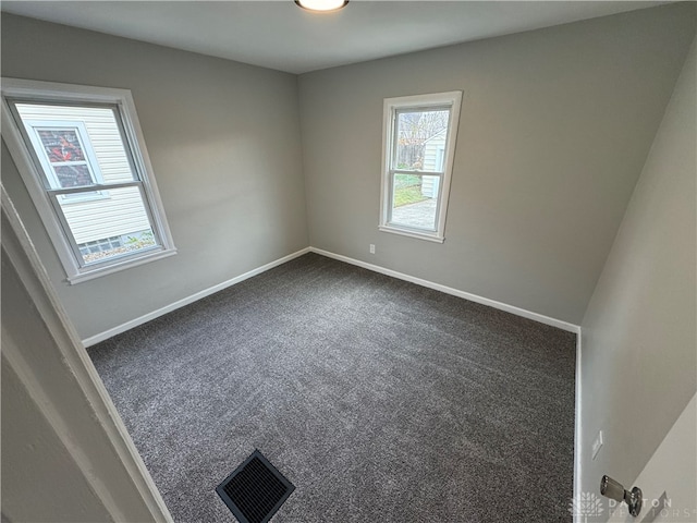 empty room featuring dark colored carpet