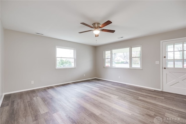 unfurnished room with ceiling fan, hardwood / wood-style floors, and a healthy amount of sunlight