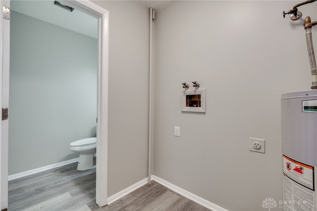 bathroom with water heater, wood-type flooring, and toilet