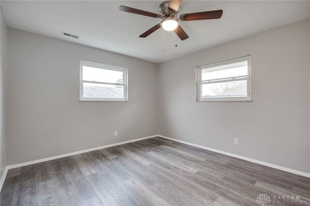 empty room with wood-type flooring, plenty of natural light, and ceiling fan