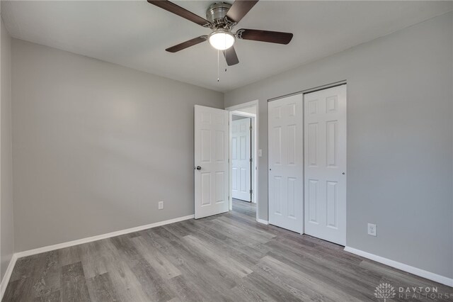 unfurnished bedroom with ceiling fan, a closet, and light hardwood / wood-style floors