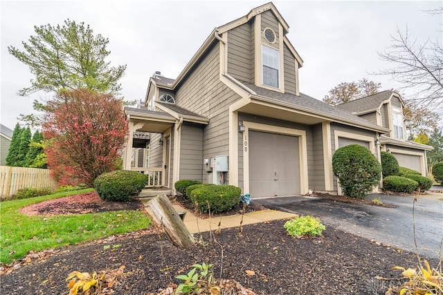 view of front of house with a garage, driveway, and fence