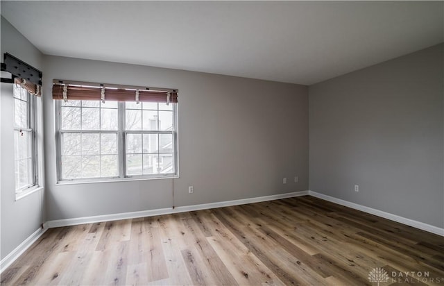 empty room with baseboards and wood finished floors