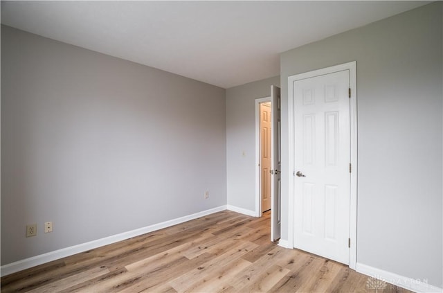 unfurnished bedroom with light wood-type flooring and baseboards