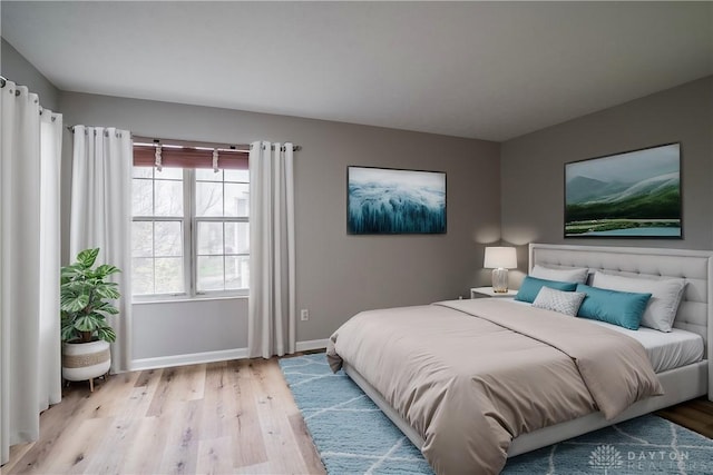 bedroom with light wood finished floors and baseboards