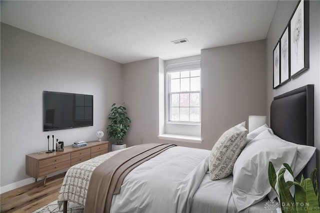 bedroom featuring light wood-style floors, baseboards, and visible vents