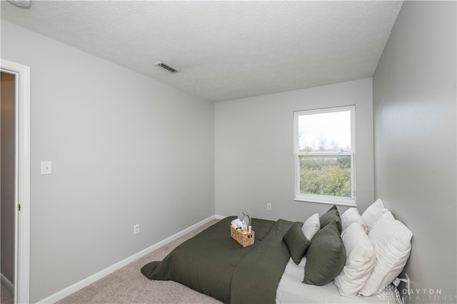 carpeted bedroom with a textured ceiling