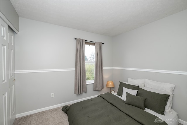 bedroom with a closet, carpet floors, and a textured ceiling