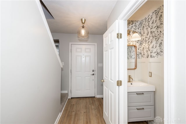 doorway to outside featuring sink and light wood-type flooring