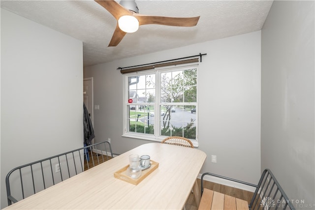 dining area with ceiling fan, a textured ceiling, and hardwood / wood-style flooring