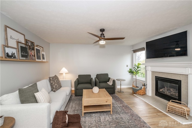 living room with hardwood / wood-style floors, a textured ceiling, and ceiling fan