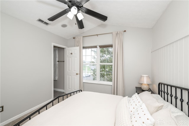 bedroom with carpet, ceiling fan, a textured ceiling, and vaulted ceiling