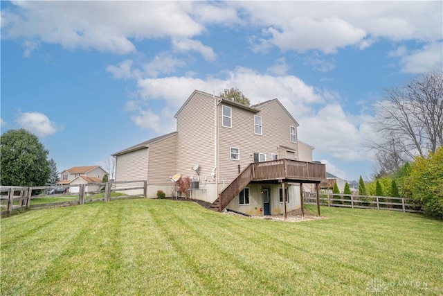 rear view of property with a deck and a lawn