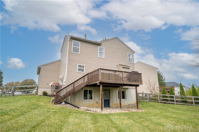 rear view of property featuring a wooden deck and a yard