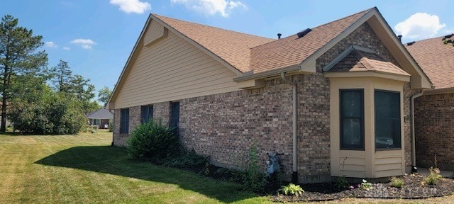 view of side of home with a yard