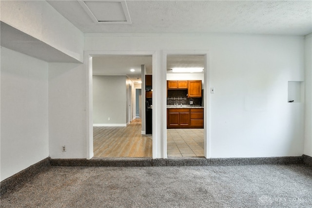 carpeted spare room featuring a textured ceiling