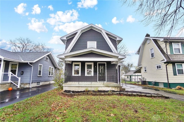 bungalow-style home featuring a front yard, a porch, and cooling unit