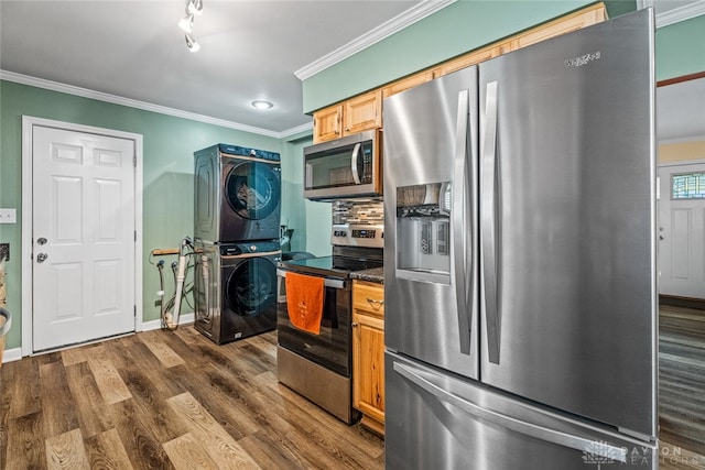 kitchen featuring stacked washing maching and dryer, dark wood-type flooring, stainless steel appliances, decorative backsplash, and ornamental molding