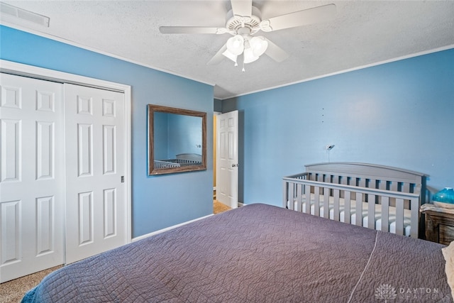 carpeted bedroom featuring ceiling fan, a textured ceiling, and a closet