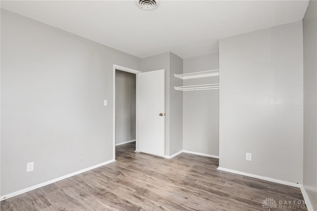 unfurnished bedroom featuring a closet and hardwood / wood-style floors