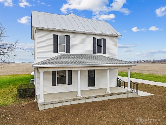 farmhouse inspired home featuring covered porch and a rural view