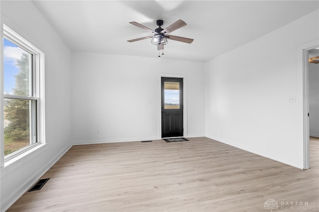 unfurnished room featuring light wood-type flooring, a wealth of natural light, and ceiling fan