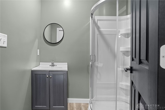 bathroom featuring wood-type flooring, vanity, and walk in shower