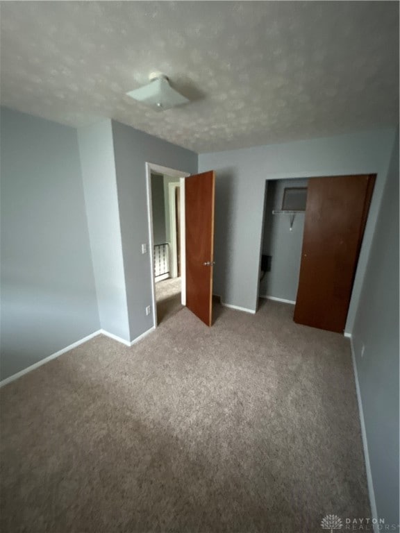 unfurnished bedroom featuring carpet floors and a closet