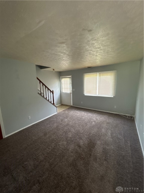 unfurnished room featuring carpet and a textured ceiling