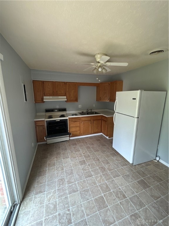 kitchen featuring a textured ceiling, ceiling fan, sink, and white appliances