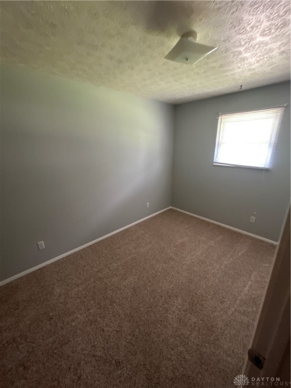 carpeted spare room with a textured ceiling