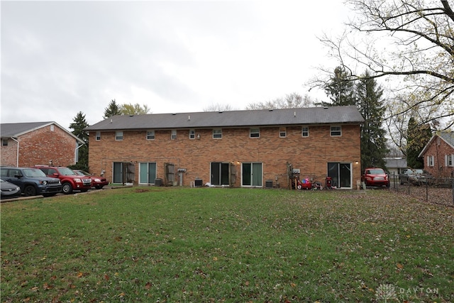 rear view of property featuring a lawn